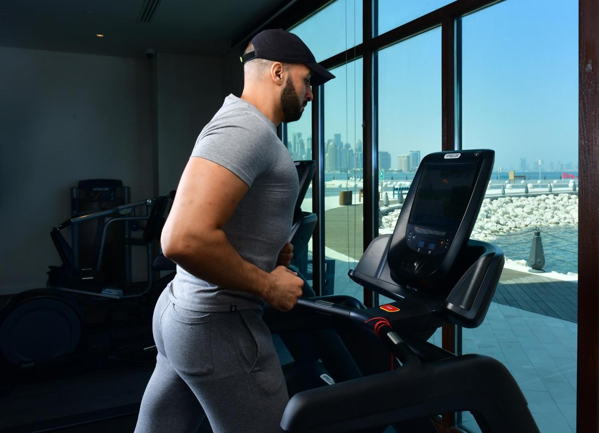 Mina Hotel And Residences By The Torch 多哈 外观 照片 A man exercising on a treadmill